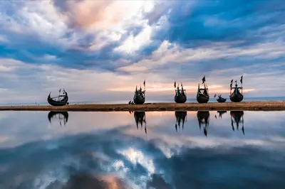 Fishing boats reflected in a tidal pool at Cox's Bazar