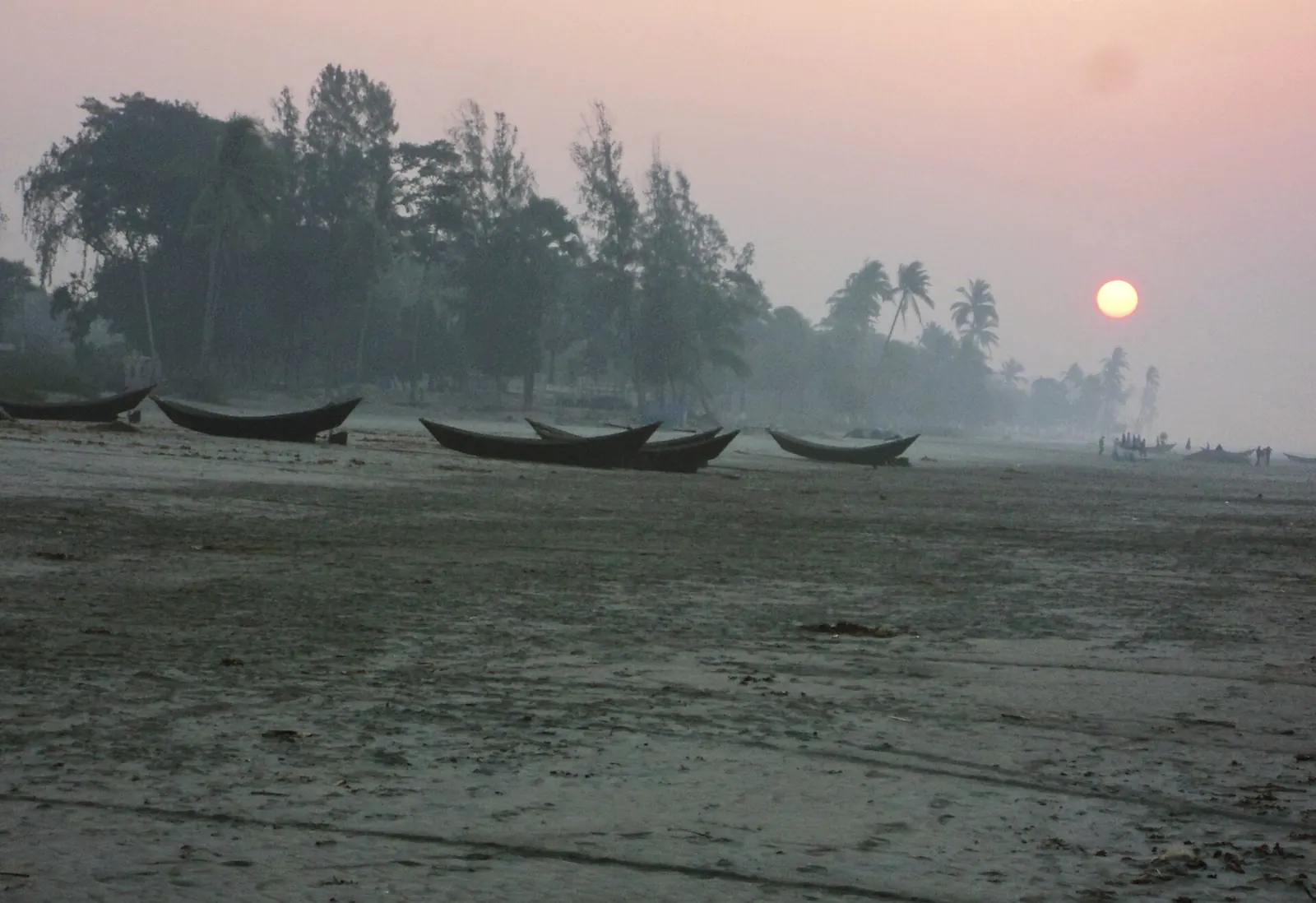 Fishing boats on the sand at Kuakata under a hazy morning sun