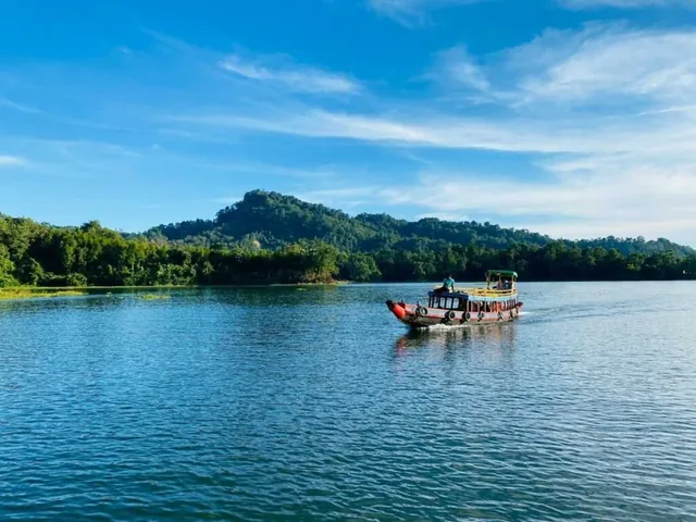 A tourist boat crossing the blue water of Kaptai Lake