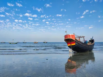 A red fishing boat at low tide off Saint Martin's Island