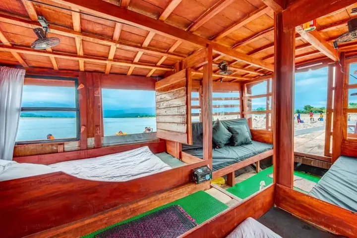 Inside a wooden houseboat cabin, with windows open onto the water