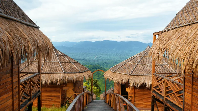 Thatched cottage roofs framing the green hills around Sajek